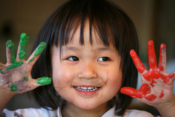 kindergartner with paint on hands